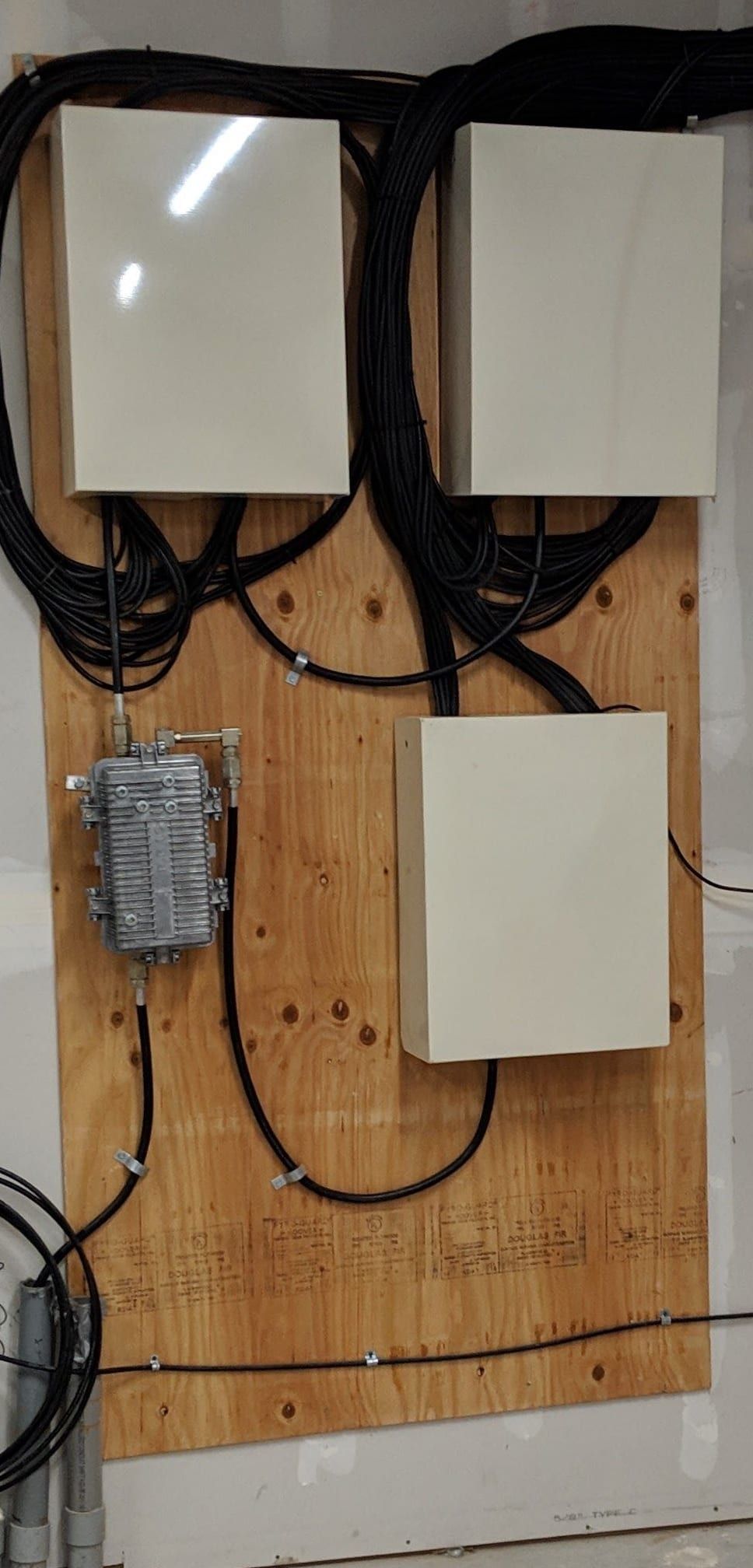 Finished backboard with three enclosures, an amplifier and dressed cable